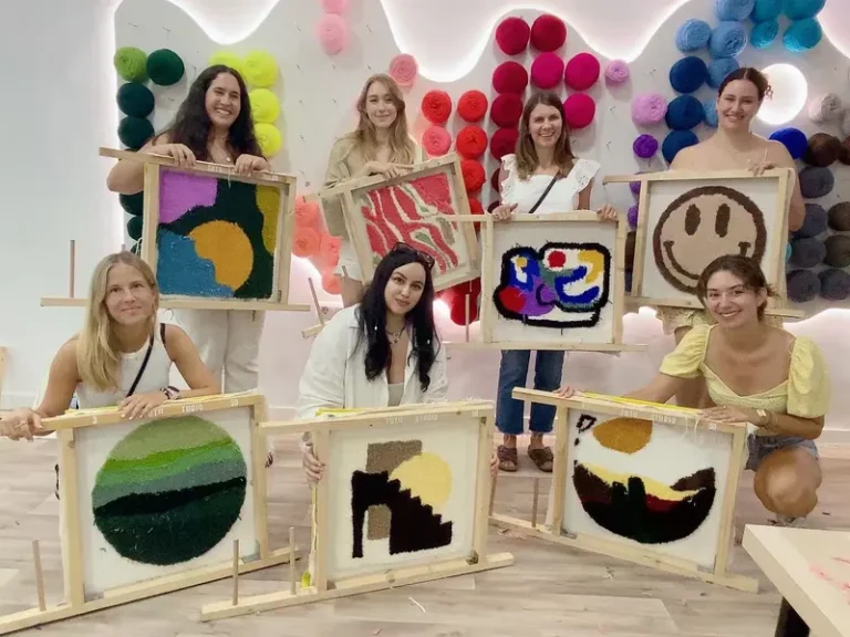 Friends holding their handmade tufted rugs at a unique bachelorette party in Barcelona